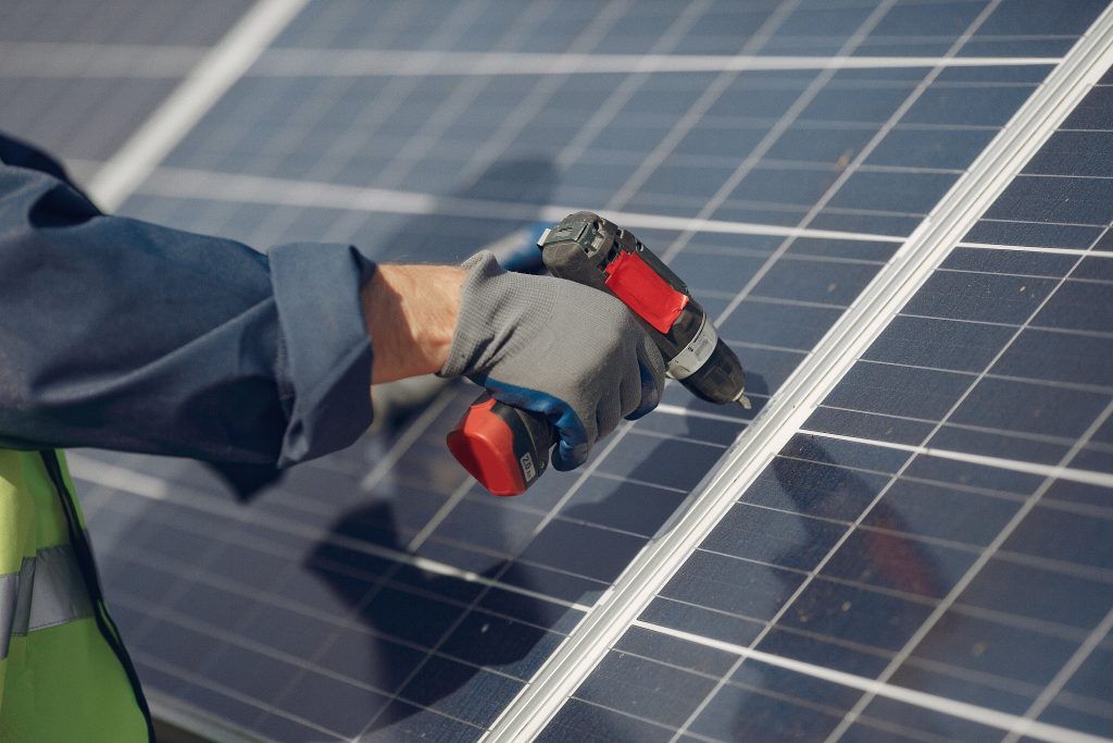man in a white helmet near a solar panel
